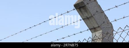 Barbed wire and blue sky in background Stock Photo