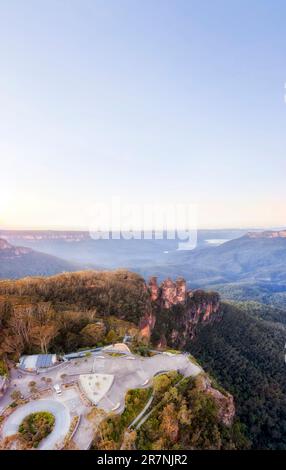 Clear sky over Three sisters rock formation in Blue Mountains of Australia in aerial vertical panorama over Echo point lookout. Stock Photo