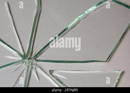 Broken glass pile pieces of texture and background isolated on white, cracked window effect. Emergency condition Stock Photo