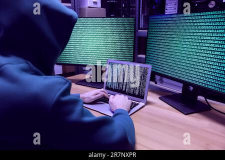 Hacker working with computers at wooden table indoors. Cyber attack Stock Photo