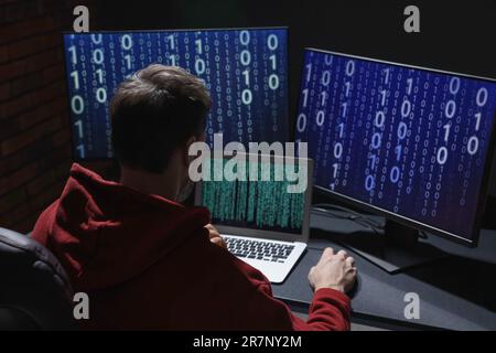 Hacker working with computers in dark room. Cyber attack Stock Photo
