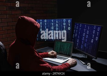 Hacker working with computers in dark room. Cyber attack Stock Photo