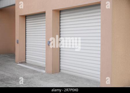 Building with white roller shutter garage doors Stock Photo