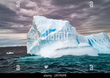 Melting iceberg with ice floe in foreground. Photographed off Antarctica. Stock Photo