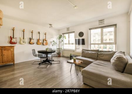 a living room with guitars hanging on the wall and an office chair in the fore - image taken from above Stock Photo