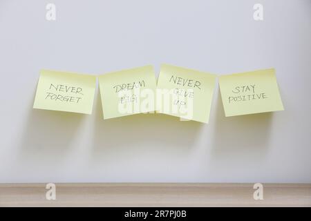 Inspiration concept, four yellow sticky notes stuck across wall with  motivational messages to never forget to dream big, never give up and stay  positi Stock Photo - Alamy