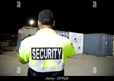 Security guard patrolling commercial storage area at night Stock Photo