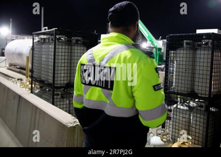 Security guard patrolling commercial storage area at night Stock Photo
