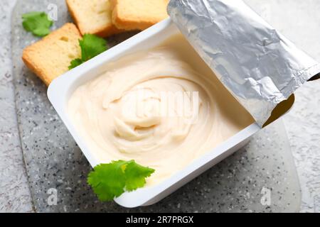 Plastic container with grated cheese on table Stock Photo - Alamy