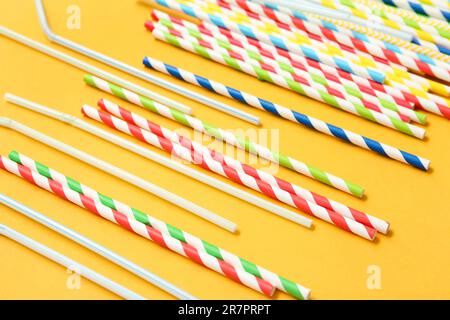 Different drinking straws on orange background Stock Photo