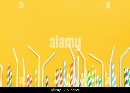 Different drinking straws on orange background Stock Photo