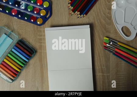 still life of objects for creativity and drawing, album, paper, watercolor drawing felt-tip pens pastels paints pencils brushes palette with copyspace Stock Photo