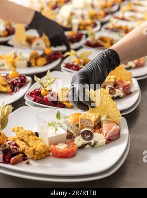 Chef is garnishing delicious appetizer dishes in restaurant kitchen Stock Photo