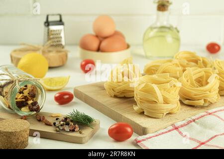 Raw and fresh homemade pasta on the table, close-up. Cooking concept. Side view on a dark background. Copy space Stock Photo