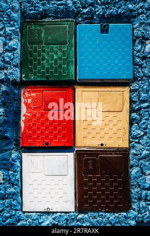 Multicolor boxes on blue wall: A lively fusion of colors, these vibrant boxes add a playful touch to the captivating blue backdrop. Stock Photo