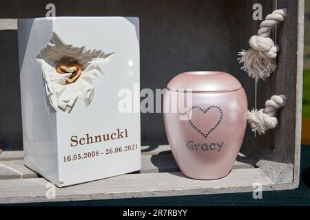Hamburg, Germany. 17th June, 2023. Urns with the inscription 'Schnucki 16.05.2008 - 26.06.2021' and 'Gracy' stand on a stand of Anubis-Tierbestattungen at the dog fair 'Kiez Dogs' on the Spielbudenplatz. Credit: Georg Wendt/dpa/Alamy Live News Stock Photo