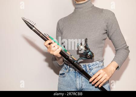 Selective Focus Cropped Woman Holds Fishing Spinning Rod, Reel on White Background. Hobby, Leisure, Sport Activity. Horizontal Plane Stock Photo