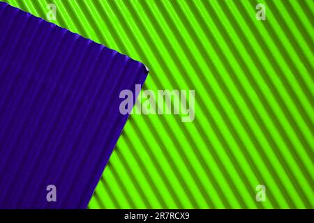 Diagonally ribbed cardboard with the colors neon green and deep purple. Meant as background Stock Photo