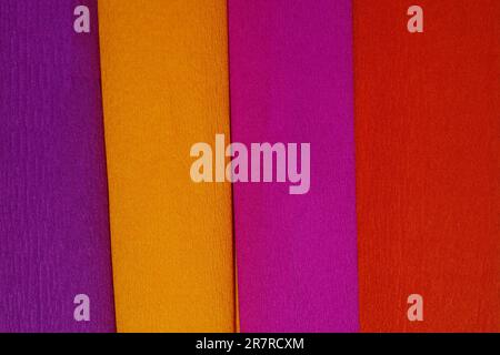 Rolls of crepe paper lying next to each other in the colors purple, red, orange, lilac Stock Photo