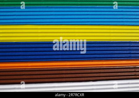 Horizontally ribbed cardboard with the colors white, brown, orange, indigo, yellow, blue, green. Meant as background Stock Photo