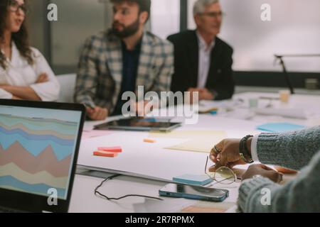 Close up of business table with laptop on and some files glasess and sticky notes Stock Photo