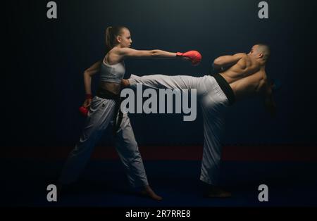 Young karate couple doing the Ushiro Kakato practice at the karate studio Stock Photo