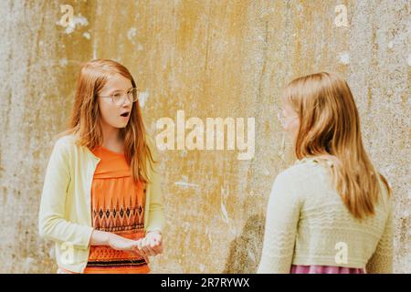 Two young expressive girls having active conversation Stock Photo