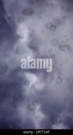 Soap bubbles are flying on gray cloudy sky background Stock Photo