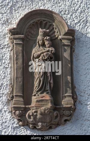 Religious sculpture of Mary with the Child Jesus on a house wall, Alken on the Moselle, Rhineland-Palatinate, Germany Stock Photo