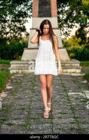Young beautiful woman with brown hair in white dress Stock Photo