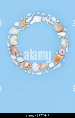Seashell and oyster pearl wreath. Decorative summer garland with collection of assorted seashells and pearls on blue background. i Stock Photo