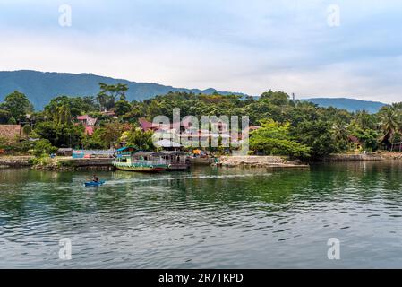 The island Samosir and peninsula Tuktuk Siadong with its resorts, within the Lake Toba, the biggest volcanic lake in the world located in the middle Stock Photo