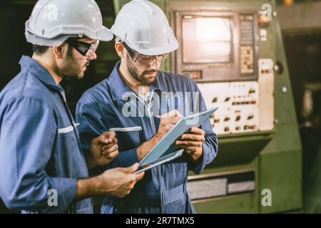 Engineer worker working together training technical give education solve machine problem in factory workplace. Stock Photo