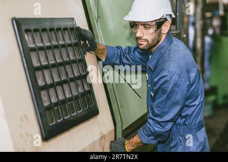 Male Worker Hispanic Latin Indian people Engineer working with CNC Lathe Machine in Heavy metal Factory. Stock Photo