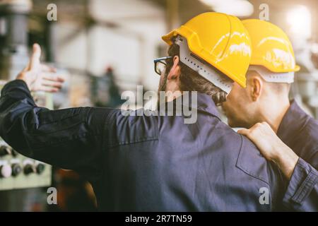 Engineer worker working together training technical give education solve machine problem in factory workplace. Stock Photo