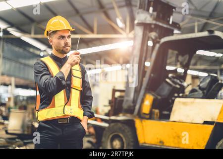 Engineer foreman using walkie talkie radio operate control loading cargo in warehouse portrait confident Stock Photo