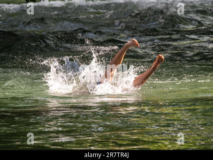 Munich, Germany. 17th June, 2023. A young man refreshes himself by jumping into the Eisbach in the English Garden, located in the heart of the Bavarian capital. Credit: Peter Kneffel/dpa/Alamy Live News Stock Photo