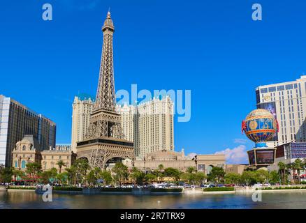 Bellagio resort fountains during a display with the fake half scale Eiffel Tower at the Paris casino and resort in afternoon sun Las Vegas Nevada USA Stock Photo