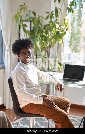 Young happy African American guy student sitting at home with laptop. Portrait Stock Photo