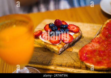 Tasty complete breakfast with a blueberry and strawberry toast and an orange juice Stock Photo