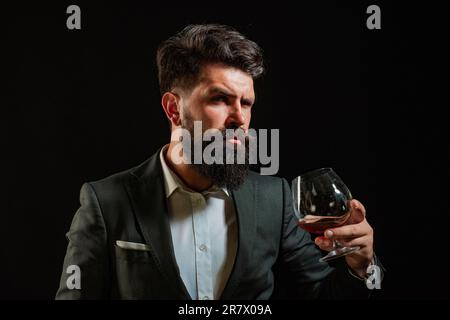 Barman or Bartender serves cognac. Retro vintage man with cognac or scotch. Sommelier man. Confident well-dressed man with glass of cognac Stock Photo