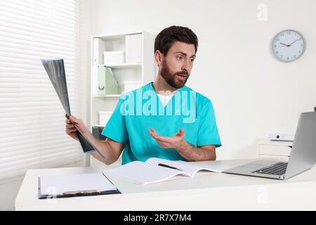 Doctor explaining MRI scan by videochat in hospital Stock Photo