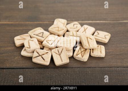 Pile of runes with different symbols on wooden table Stock Photo