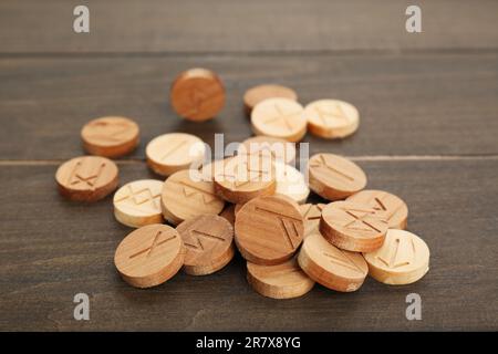 Pile of runes with different symbols on wooden table Stock Photo