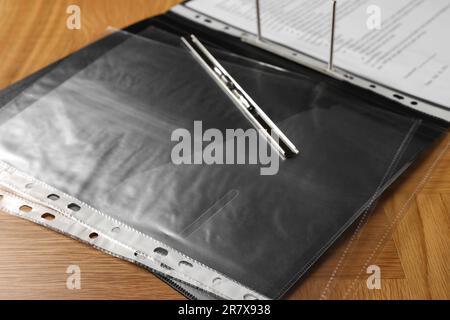 File folder with punched pockets on wooden table, closeup Stock Photo