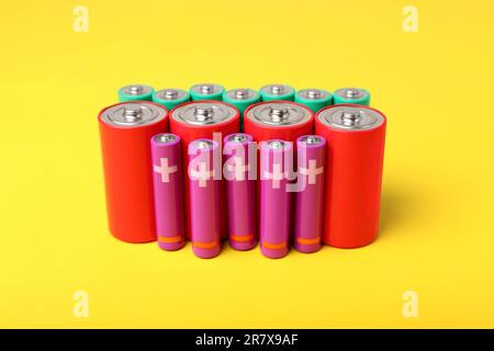 Batteries of different sizes on yellow background Stock Photo