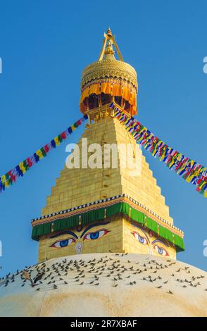 The dome and gold spire of Bodhnath Stupa, Kathmandu, Nepal, with Buddhist prayer flags Stock Photo
