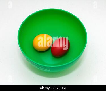 Coloured cooked chicken eggs in green plastic bowl Stock Photo