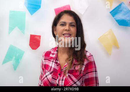 Portrait of woman dressed in character. Sao de Joao party. Isolated on white background with colored flags. Stock Photo