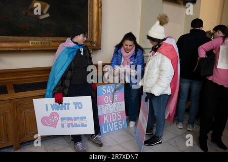 Marietta, Georgia, USA. 20th Mar, 2023. Danamarie DeRiggi checks legislator's schedules at the Georgia statehouse with transgender son Jayson Achtenberg, 13, (left) and his non-binary sister Isabella, 15. The family joined dozens of trans right activists on the day before a crucial vote, petitioning state senators to vote against a bill that limits gender-affirming care for residents under 18 years. Their efforts were unsuccessful, and the law was passed. SB140 become effective July 1. (Credit Image: © Robin Rayne/ZUMA Press Wire) EDITORIAL USAGE ONLY! Not for Commercial USAGE! Stock Photo